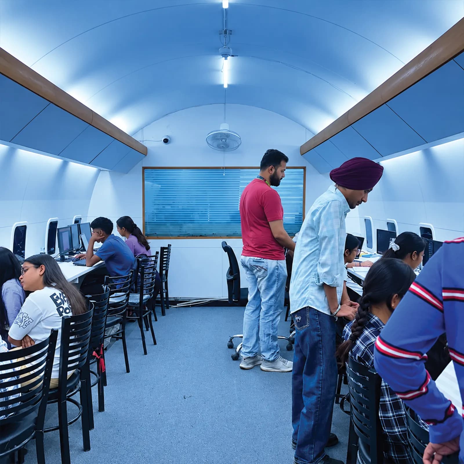 Trainers checking students' work in the aircraft-cabin computer lab