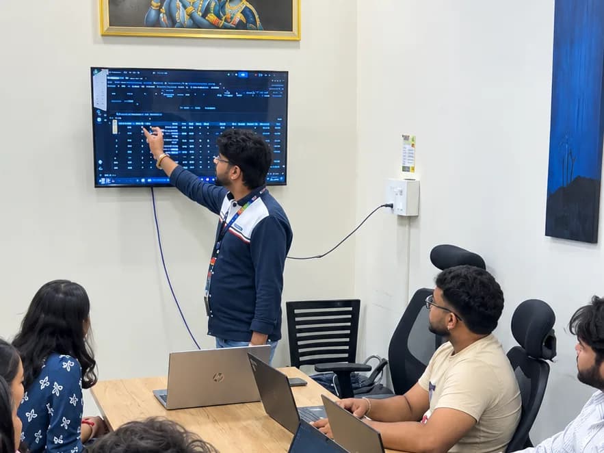 Trainer pointing out data on the wall screen during a session