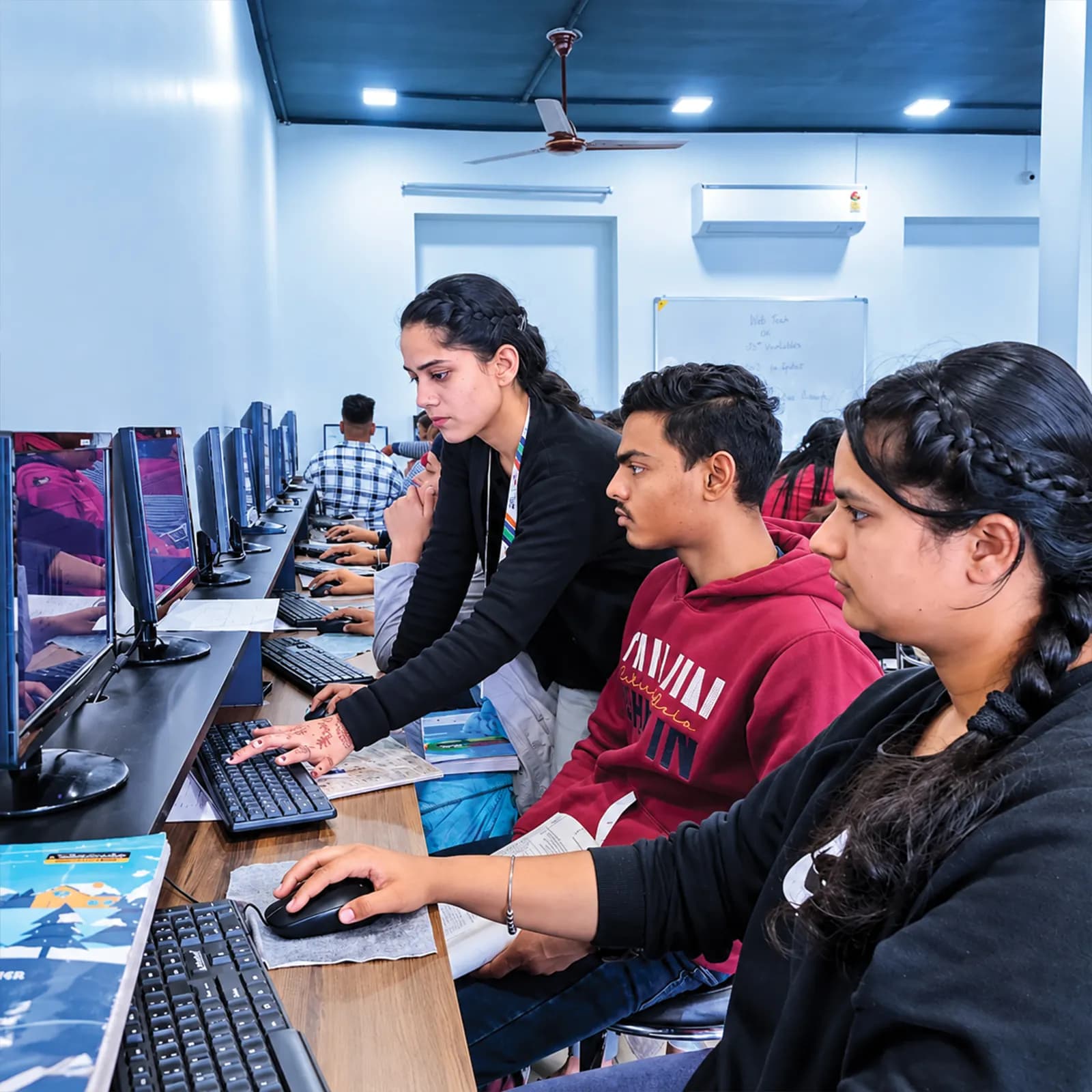 Trainer guiding a student through an exercise at the computer