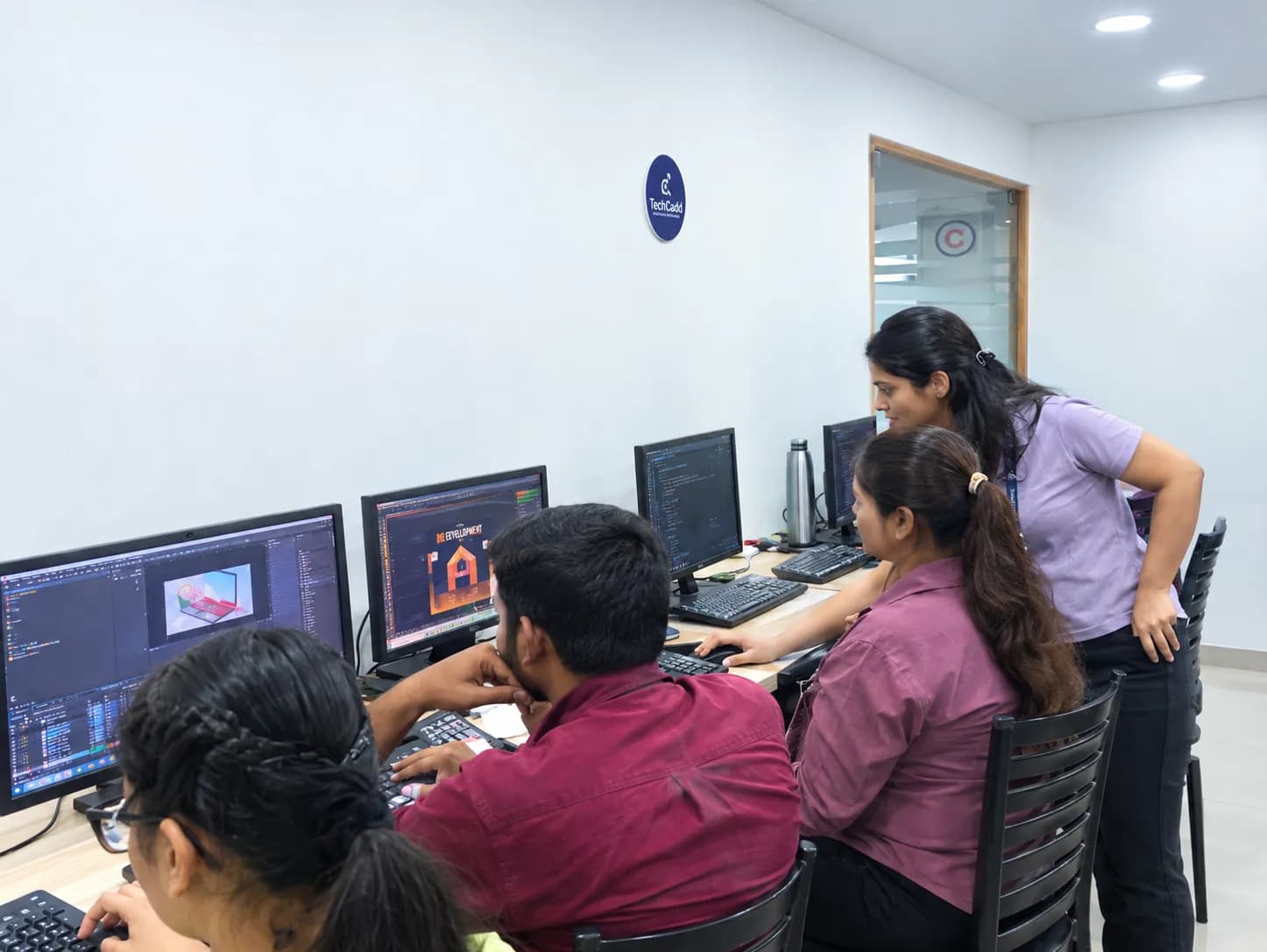 Trainer reviewing a student's design work at the workstations