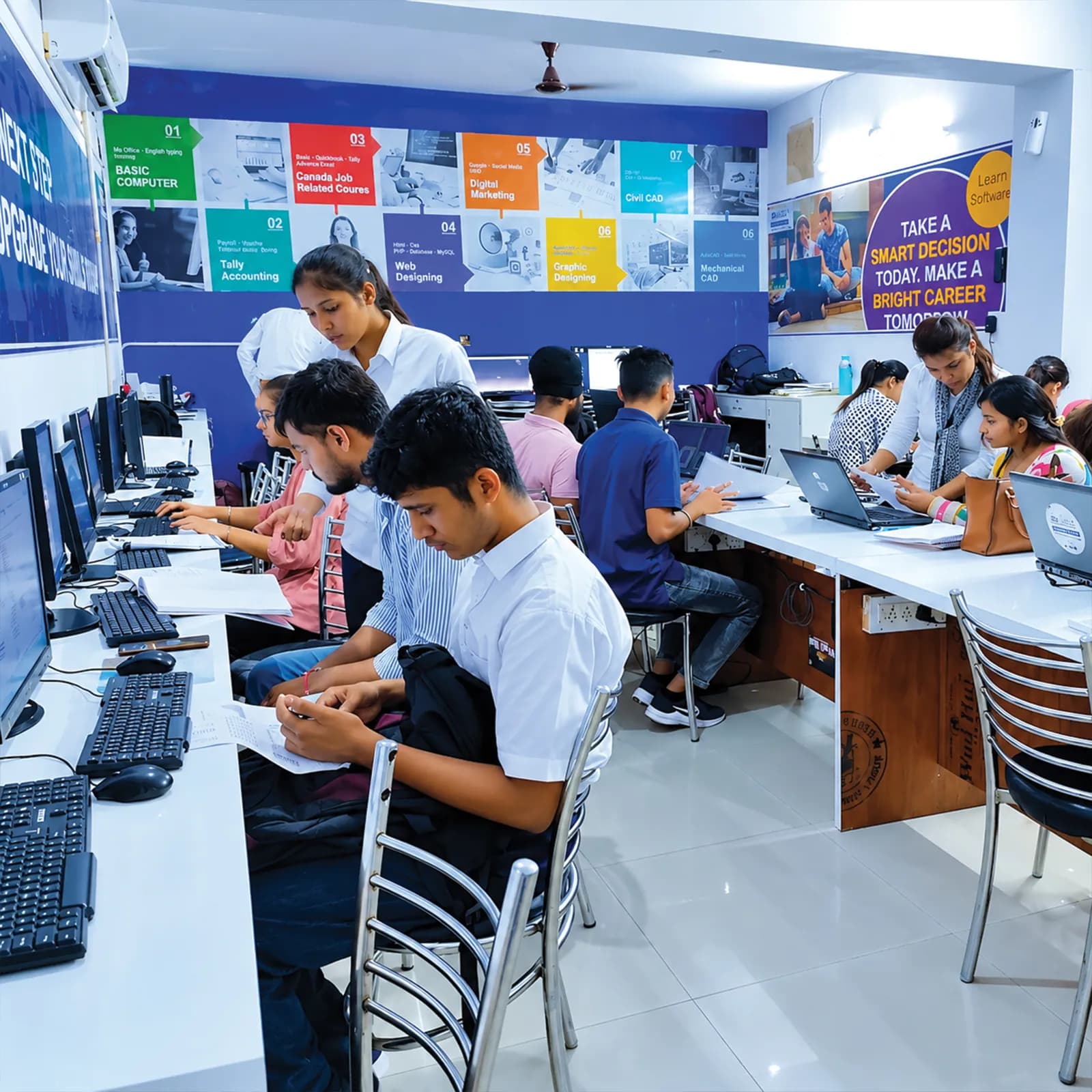 Trainers helping students in the computer lab